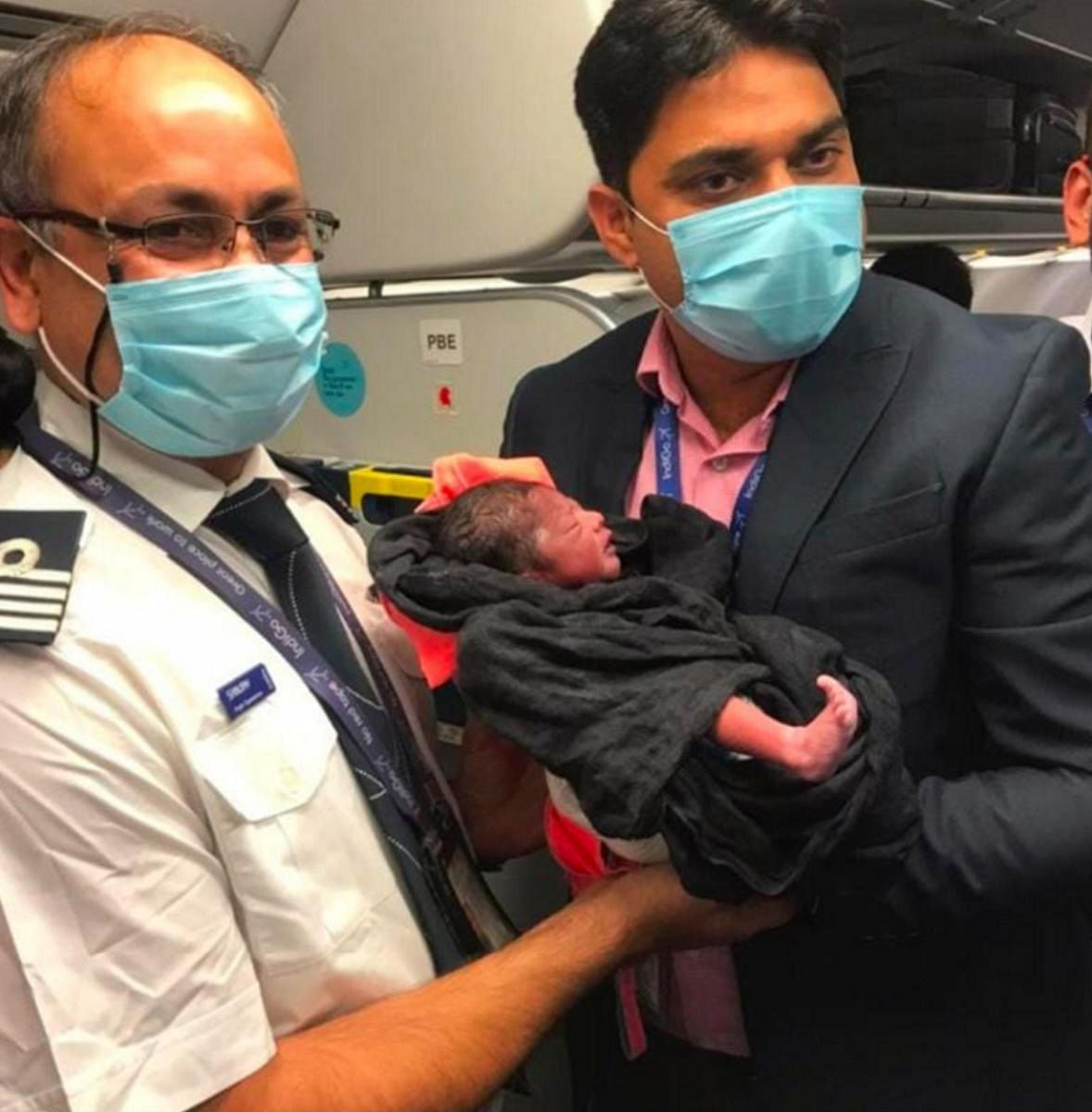 Members of the flight crew holds the baby inside the plane. 