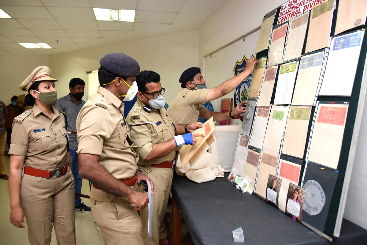 Senior police officers examine the fake stamp papers displayed at the Bengaluru police commissioner's office on Saturday. DH PHOTO/S K DINESH