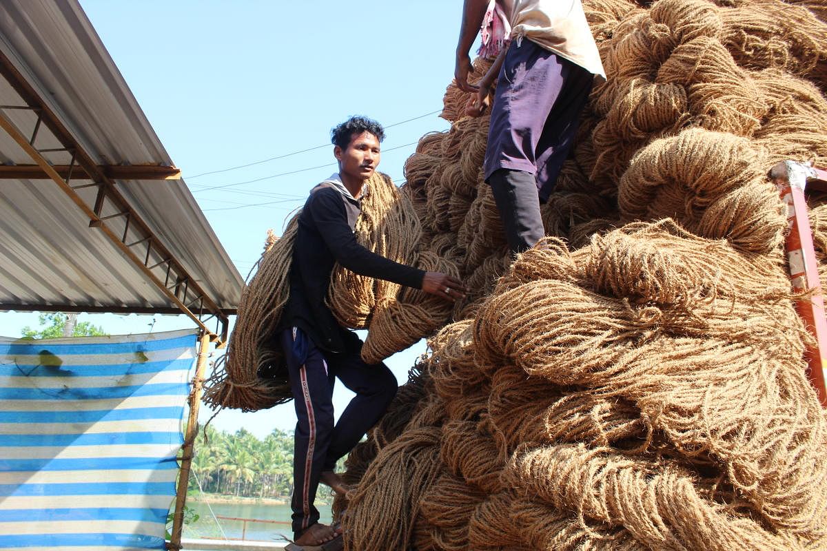 Labourers loading coir ropes to a truck.