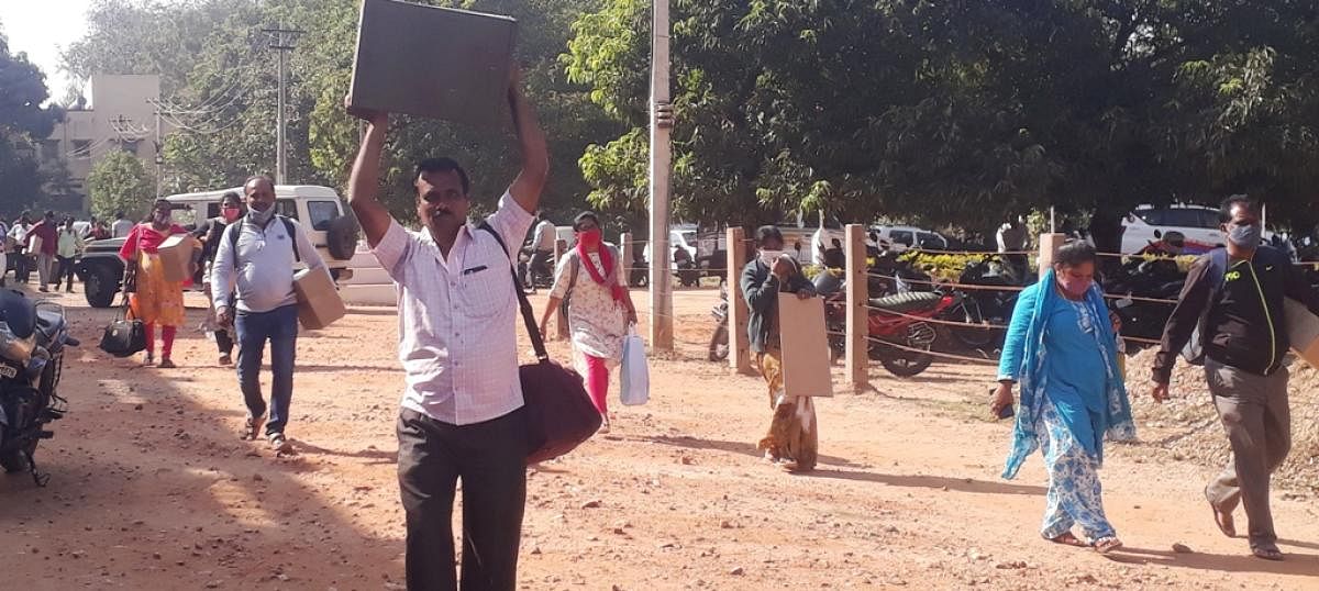 Officials, along with ballot box and other requirements, head towards the voting centres on Saturday. DH Photo