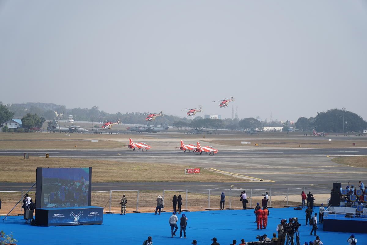 Hawks of the Surya Kiran aerobatics team and ALHs of the Sarang Air display team prepare to carry out a combine maneuver at Aero India 2021 on Wednesday.