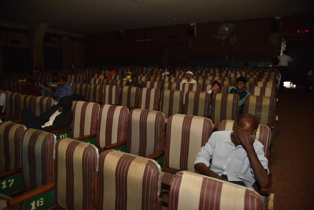 Social distancing is the norm. Viewers sit seats apart at Santosh theatre, which in pre-pandemic times would have seen a packed house. DH Photo by B B K Janardhan