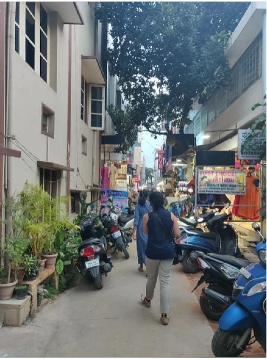 A conservancy lane, taken over by hawkers and parked vehicles.