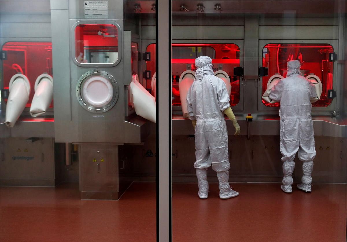 Employees operate a machine inside a lab at the Serum Institute of India in Pune. Reuters 