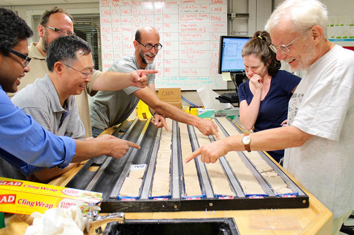 Scientists debate the location of the Cretaceous/Paleogene boundary on a core sample aboard the Joides Resolution.
