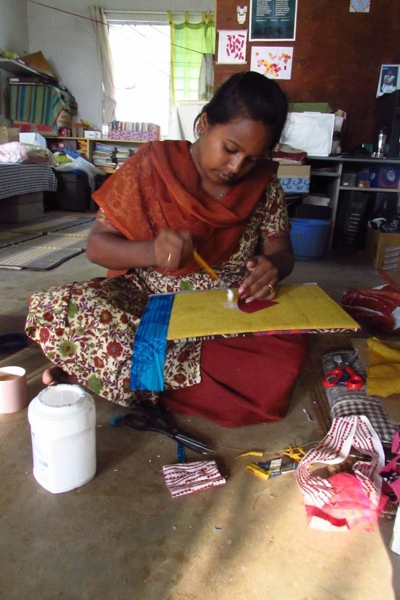 Pallavi, a girl from Jyothipalya, working on an art file made of discarded cardboard cartons and fabric under the guidance of Sabiha Hashmi.