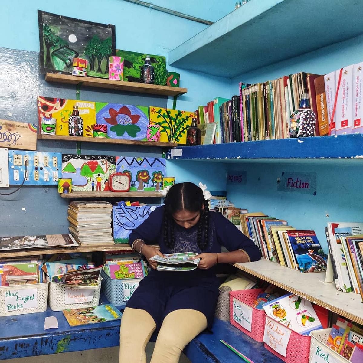 A girl engrossed in reading at the Haadibadi Community Library in Bengaluru.