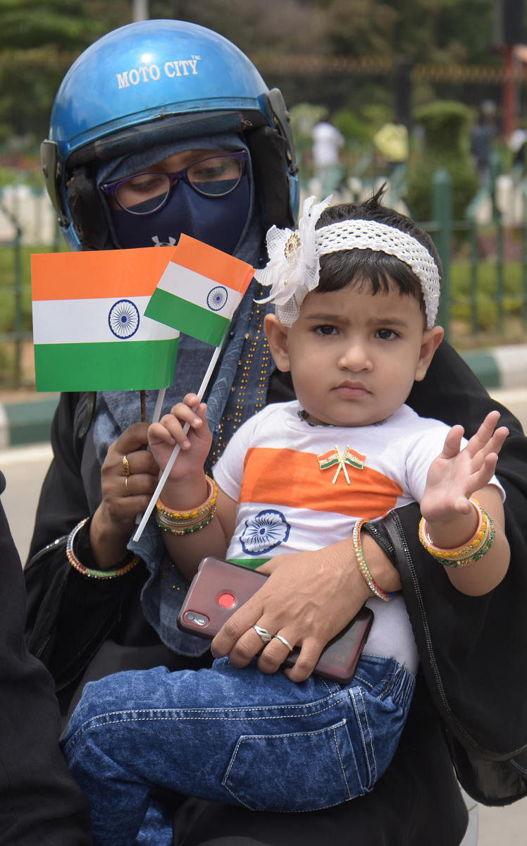 A woman and a child show India flags. Credit: DH Photo/Pushkar V