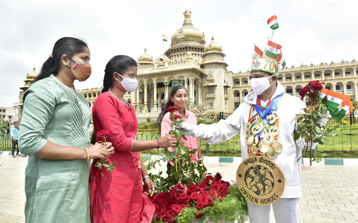 Paramesh Jolad, an artist, gifts people roses as part of a campaign to remember the unseen heroes on Independence Day. Credit: DH Photo/Prashanth H G