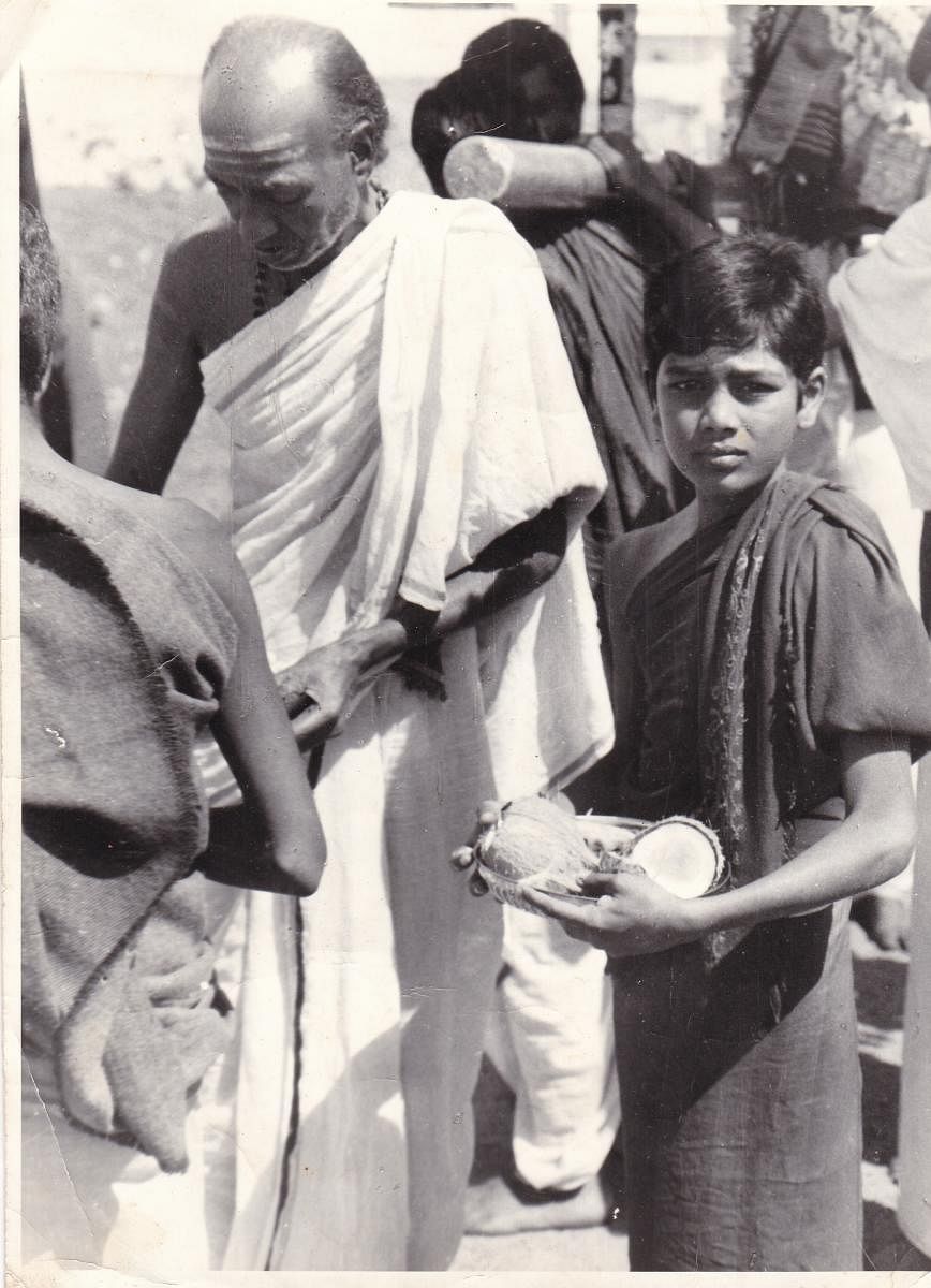 Young N Shashishekara Dixith accompanies his grandfather Narayana Dixith during Chamundeshwari Devi Utsava atop the Chamundi Hill in Mysuru.