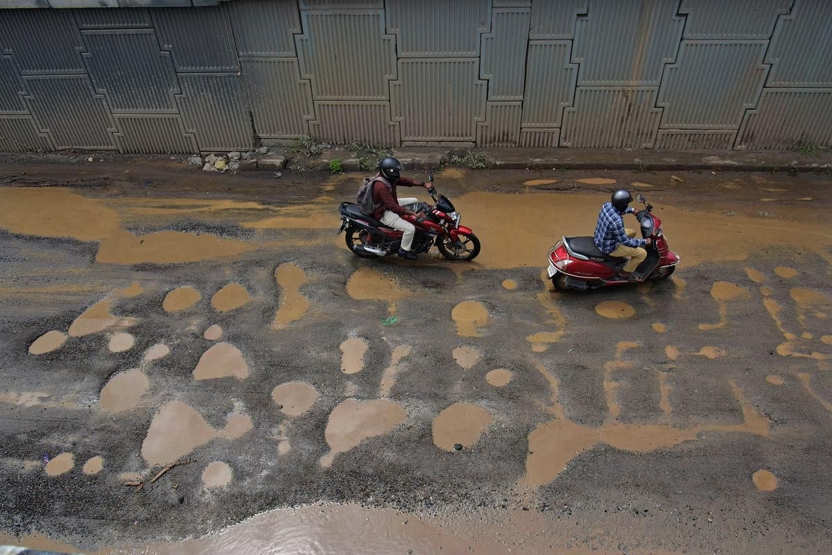 Commuters navigate pothole-ridden roads on the busy Outer Ring Road near Manyata Tech Park following heavy rains. DH FILE/PUSHKAR V