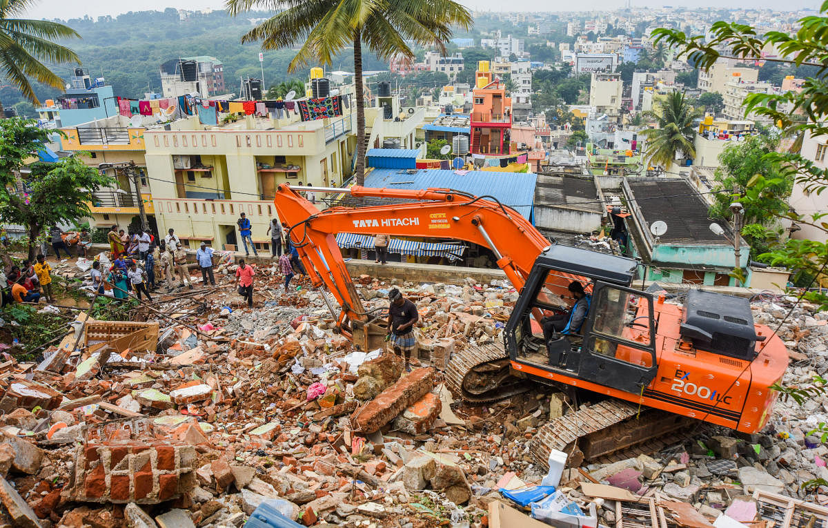 An earthmover is helping the residents retrieve their belongings from the rubble. Credit: DH Photo