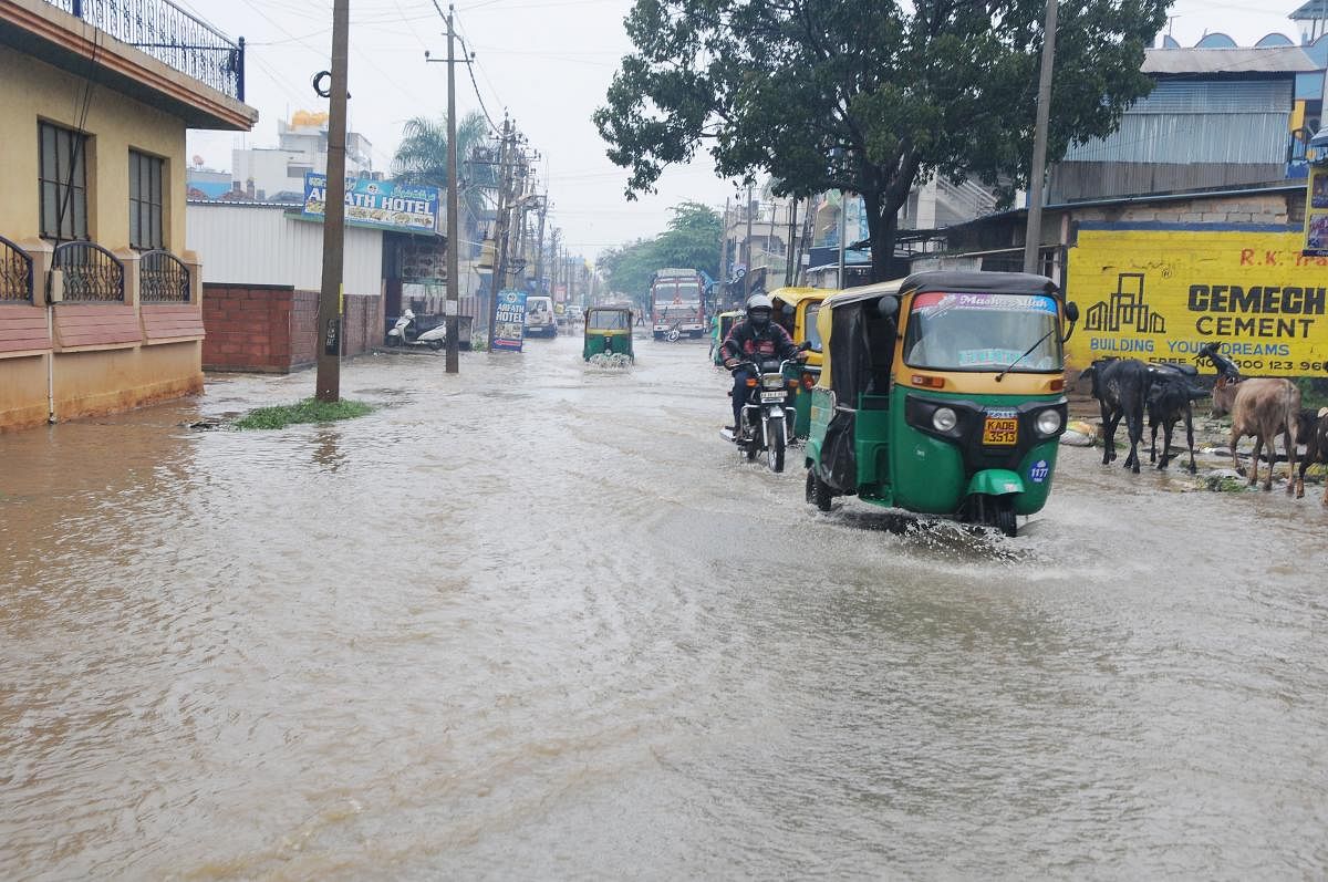 Vehicles ply on a flooded road in Tumakuru. DH Photo