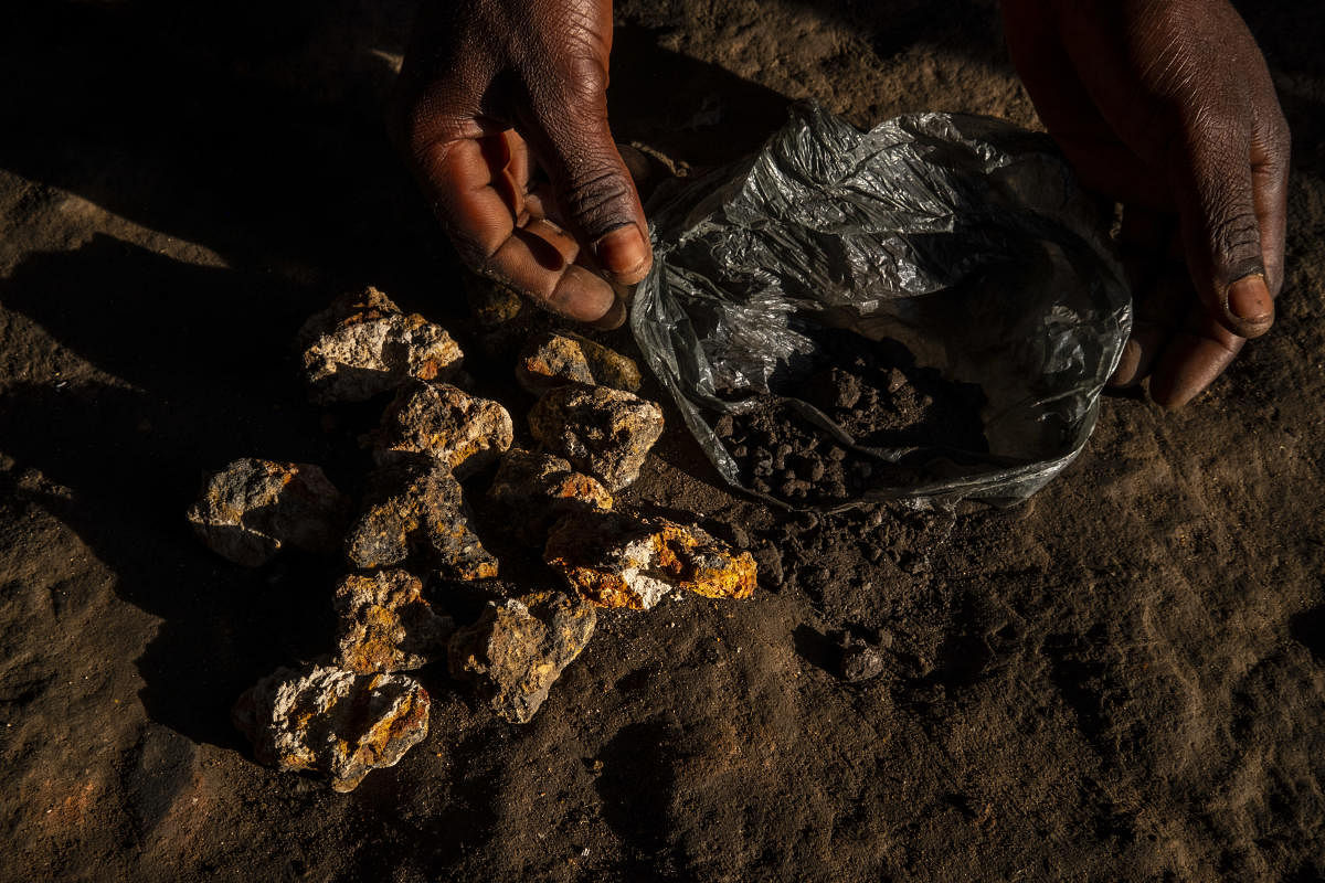 A resident living near the Kisanfu mine showed off. rocks he found there that contain cobalt Credit: Reuters Photo