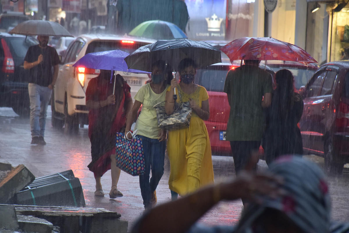 Umbrellas were out on Commercial Street, Bengaluru, on Wednesday evening. Credit: DH Photo