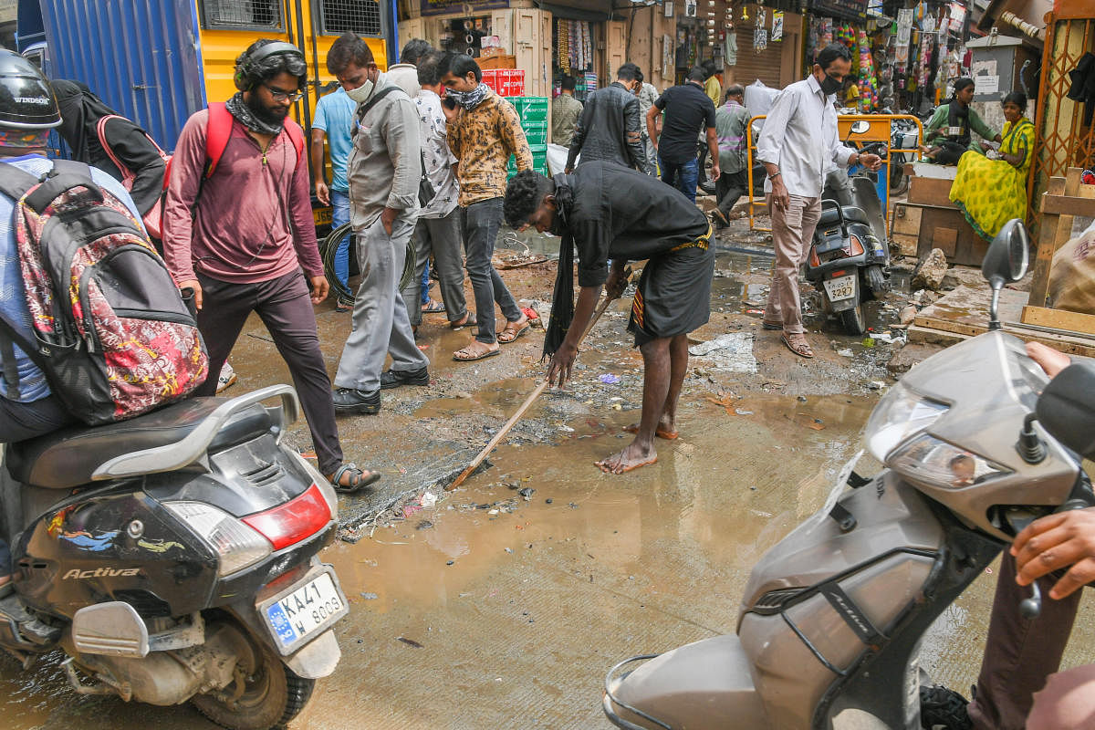 Citizens try to clear the clogged drain. Credit: DH Photo/S K Dinesh