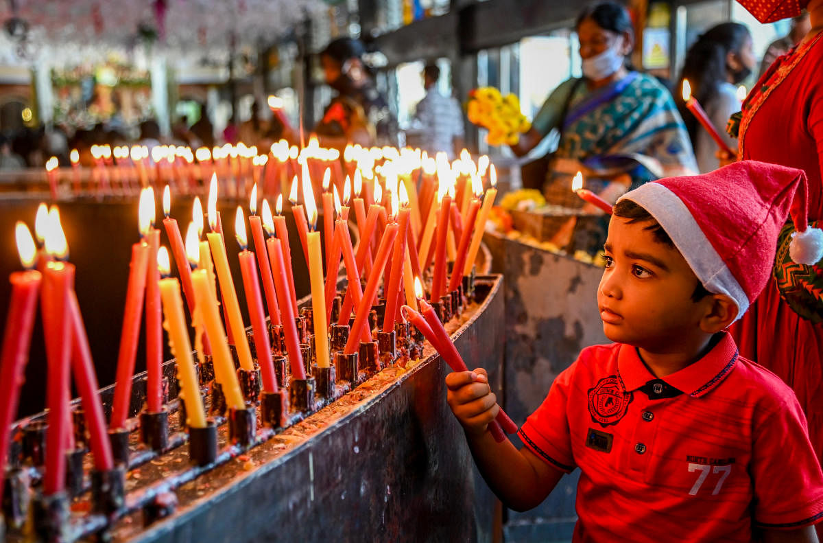 A child lights candles at St Mary’s Basilica in Shivajinagar on Christmas eve on Friday. Credit: DH Photo/M S Manjunath