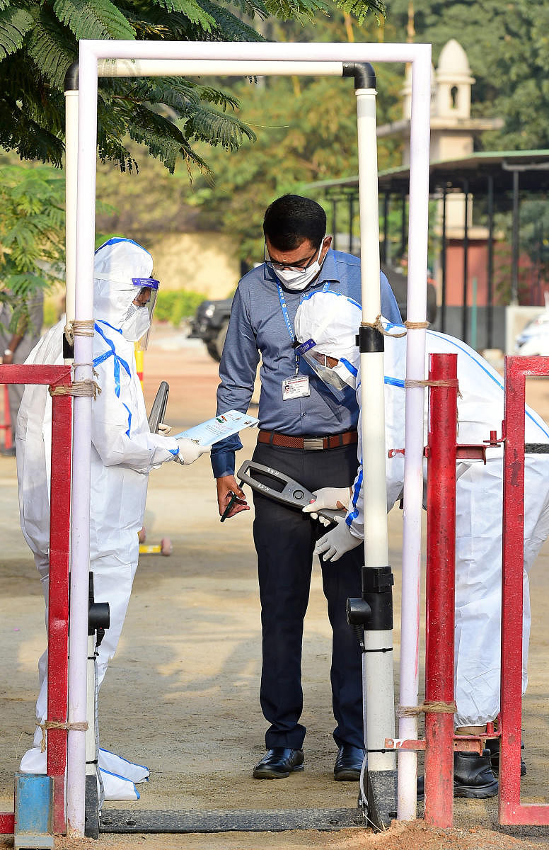 Cops put on PPE kits to frisk invitees to the event. DH PHOTO/RANJU P