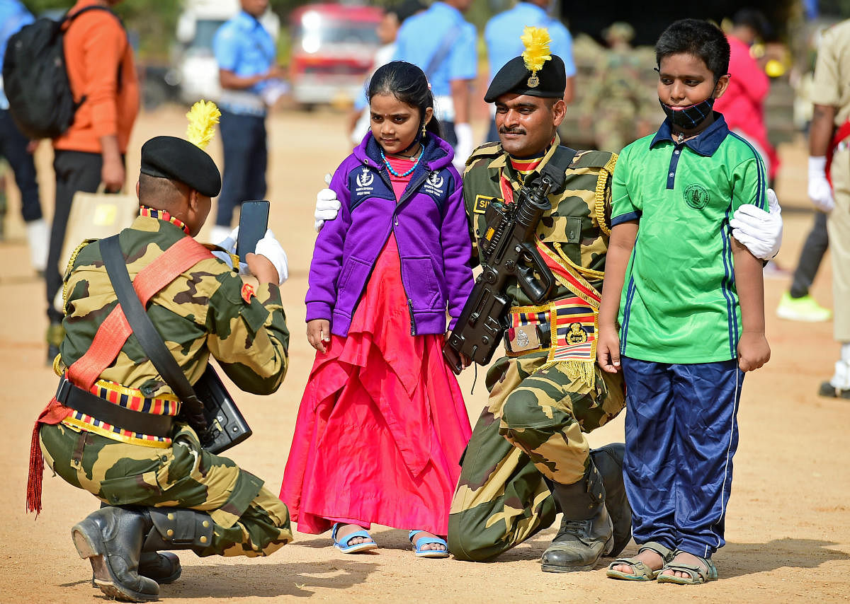A BSF jawan takes a photo of his colleague and his children during the R-Day event at the Manekshaw Parade Ground in Bengaluru on Wednesday. DH PHOTO/RANJU P