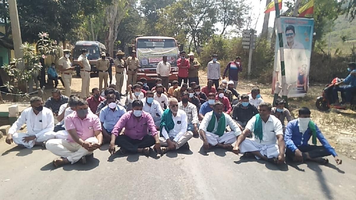 Raitha Sangha members stage a protest at Punajanur check post in Chamarajanagar on Thursday. DH Photo