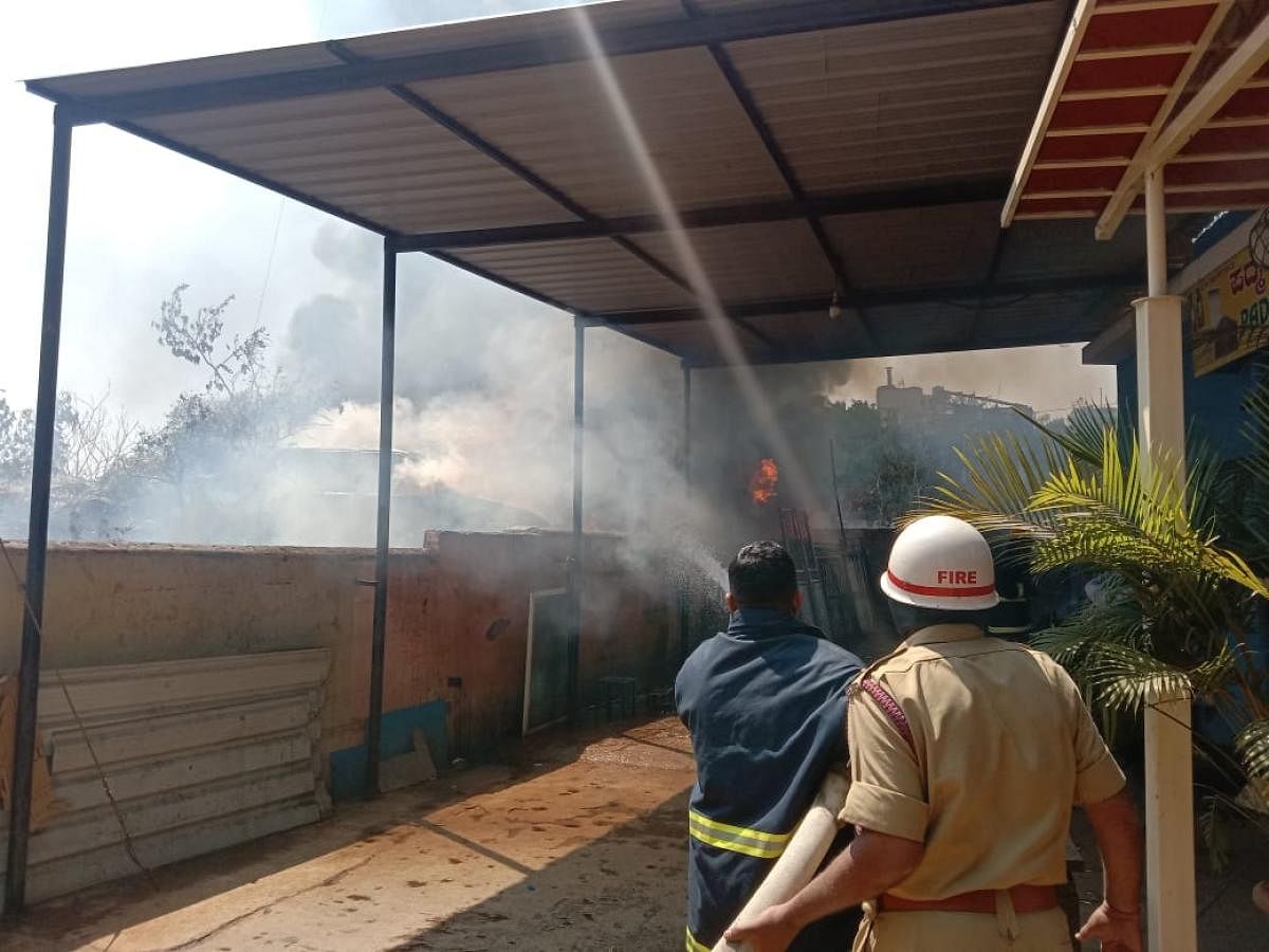 Fire and emergency service officials douse the flames at the Kengeri police station on Friday. Credit: Special arrangement