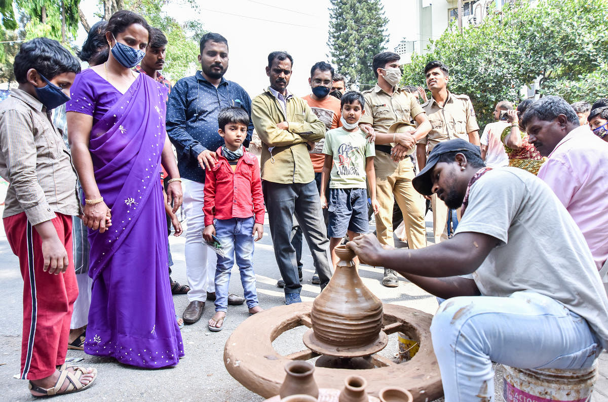 A potter showcases his skills to a group of curious onlookers.