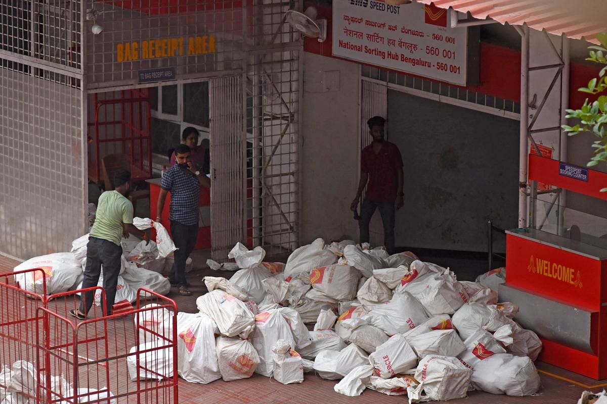 At 7:55 am, a red postal truck from Mangaluru arrived at the GPO building, just outside the ‘National Sorting Hub’. More than 50 plastic bags containing posts and parcels with tags like ‘Maharashtra Circle’, ‘Kerala Circle’, ‘Hyderabad Circle’, ‘Coastal Circle’ and other regions were offloaded in the open. Credit: DH Photo