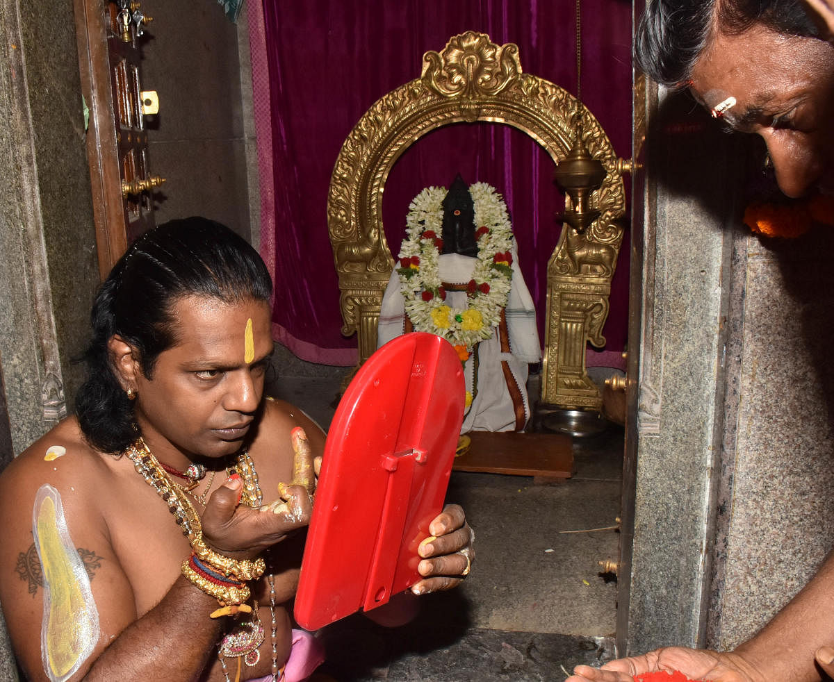 A Jnanendra has been carrying karaga, the ritualistic floral pyramid symbolic of Draupadi, for 11 years. Karaga-carrying priests like him are required to build physical strength, stay away from home, and dress in saree and jewellery for rituals. He runs a