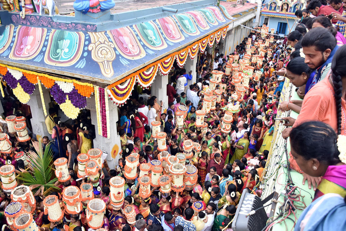 TOWERING: Men perform a majority of Karaga rituals. But during Aarathi Deepotsava, women and girls hit the road in the wee hours carrying a vessel and a tall column of flowers on the head for two kilometres.