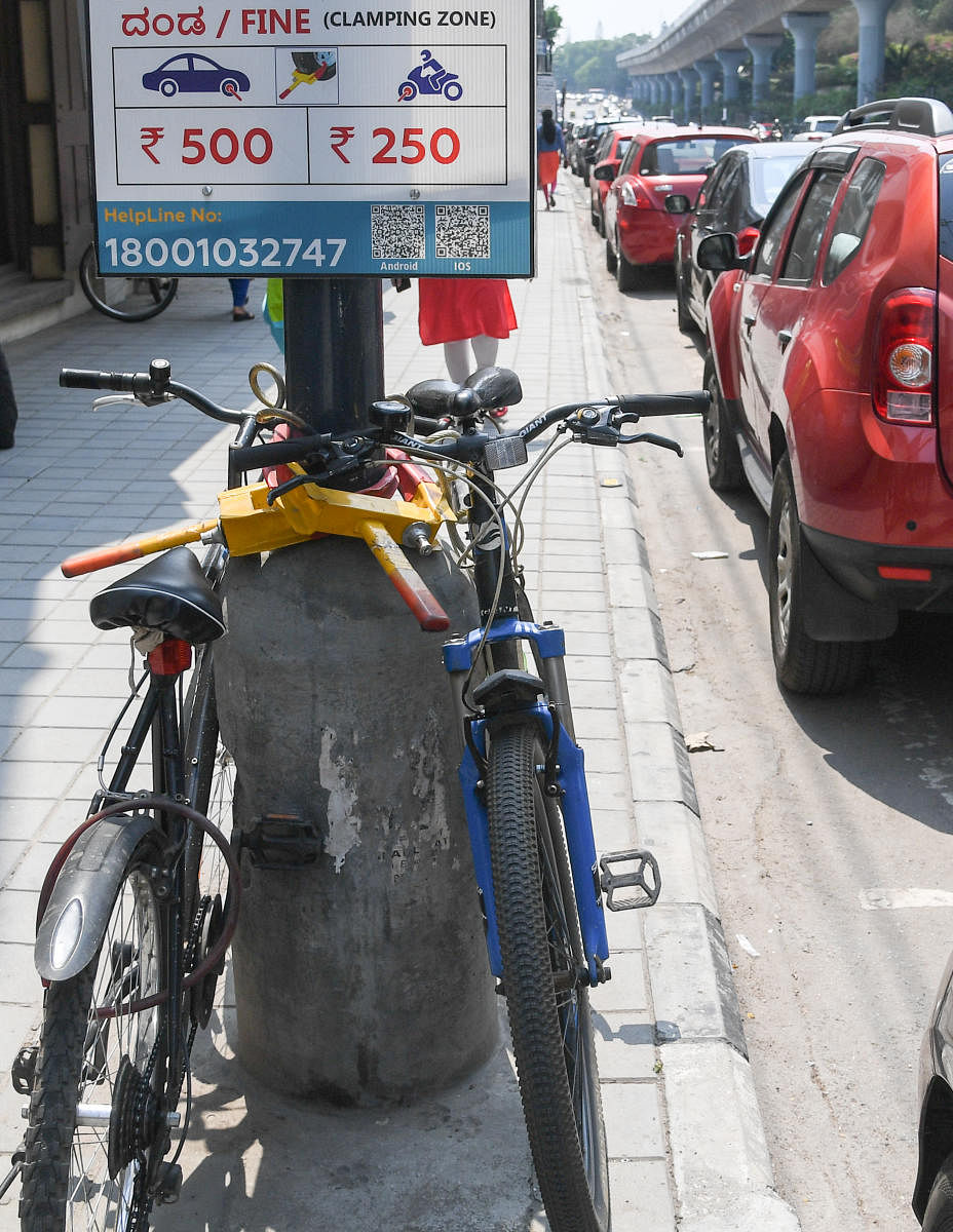 In dearth of dedicated cycle parking in Bengaluru, people tether their cycles to lampposts, trees, in front of shops, or park in the two-wheeler zone. Credit: DH Photo/B H Shivakumar