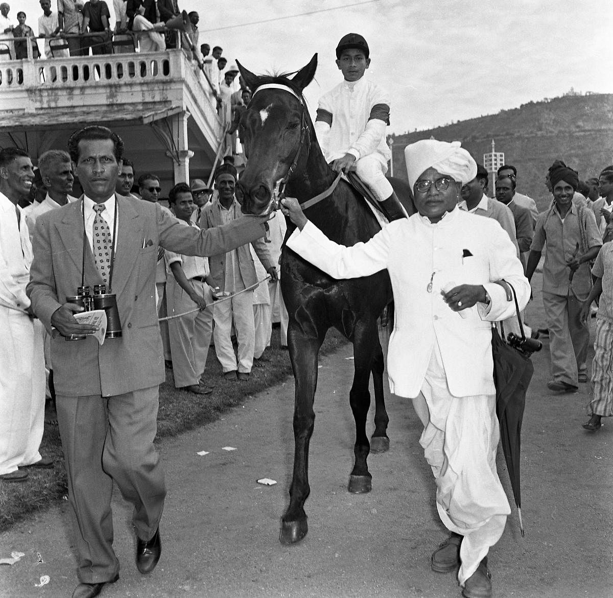 Grandfather leading a horse at the races