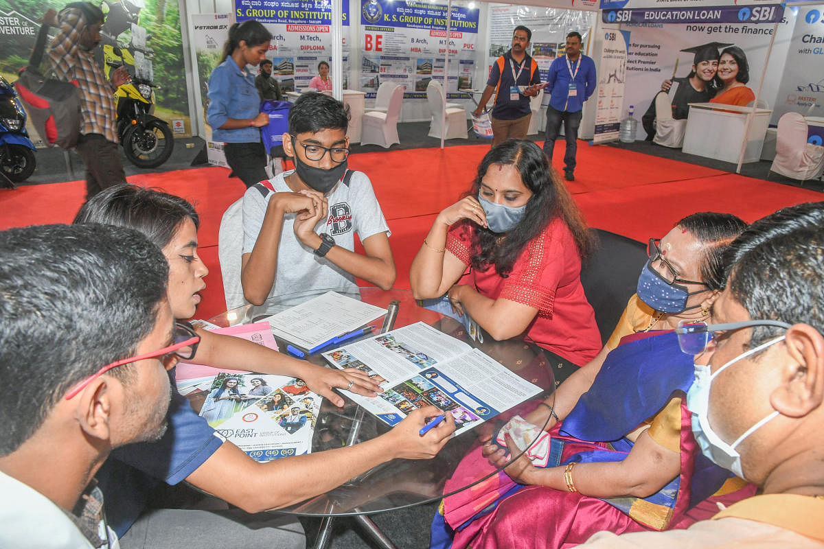 A volunteer gives necessary information to students and parents at a stall at the expo.
