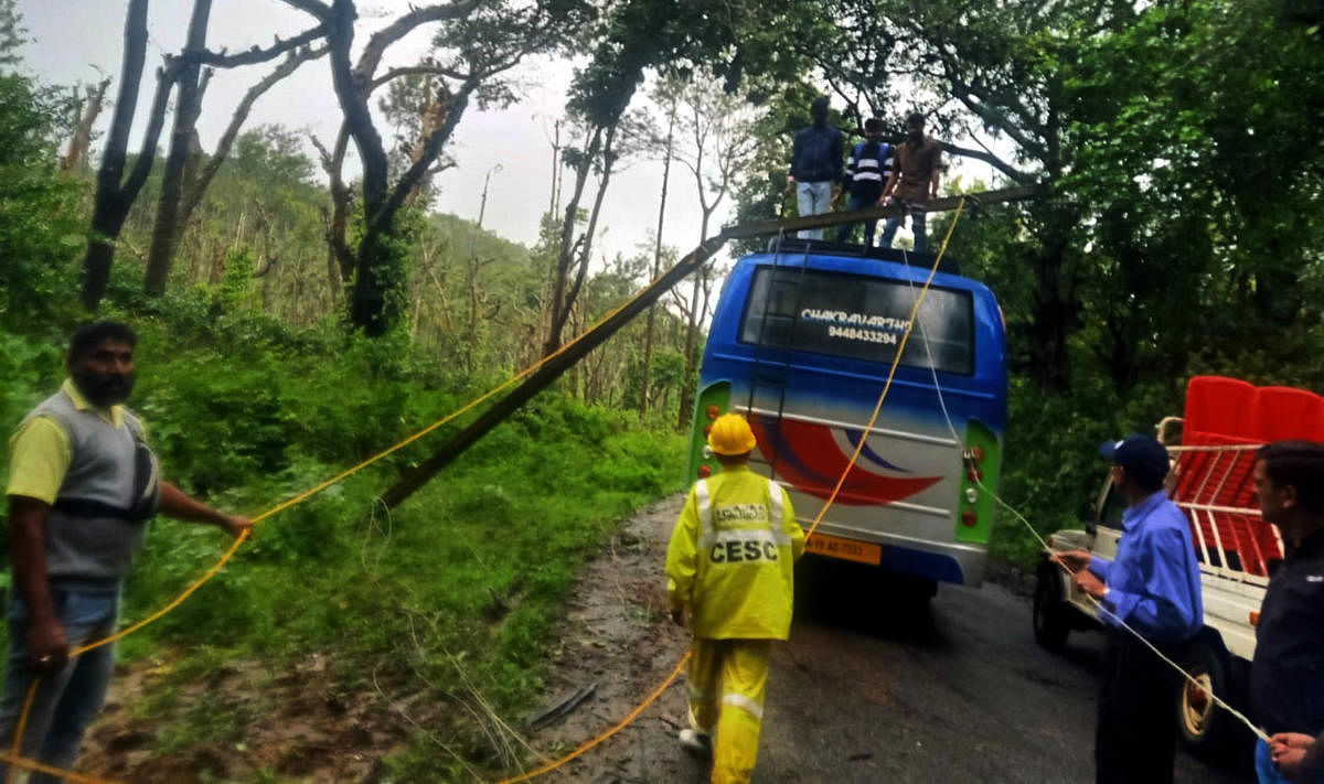 CESC personnel repair an electricity pole by climbing a private bus at AloorSiddapura.
