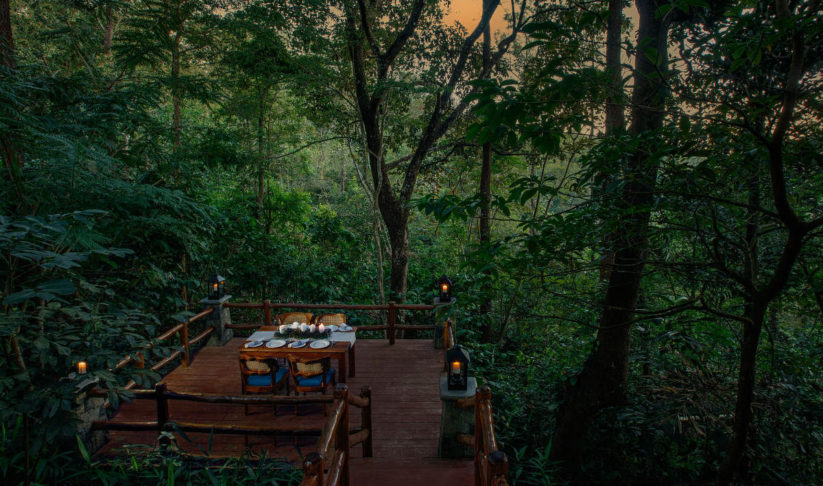 An outdoor dining space at a holiday home located at Wayanad, designed by Earthitects. When a building comes in the way of a tree or a boulder, the layout is modified and goes around it. Credit: DH Photo