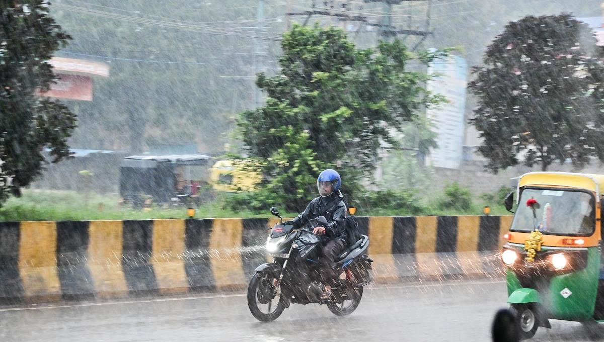 A motorcyclist braves showers in Davangere. Credit: DH Photo