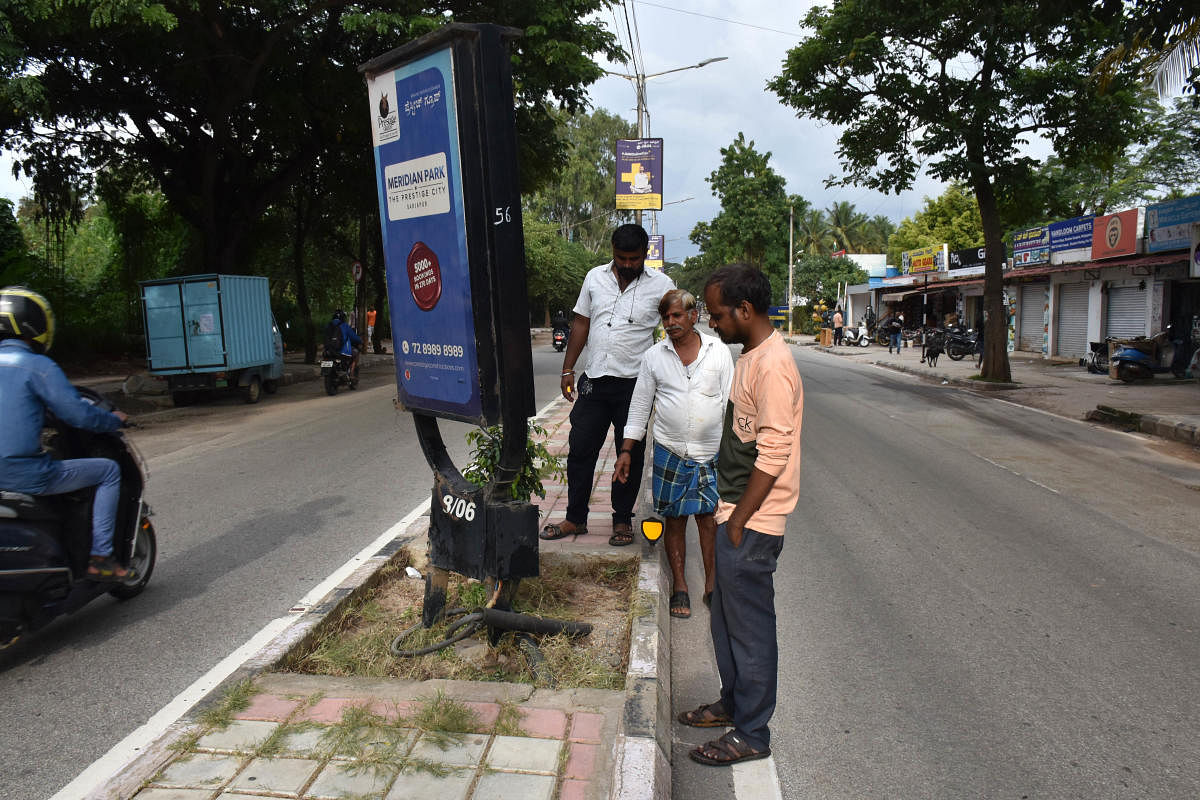 Akhila tried to hold on to an advertisement hoarding on this stretch at Siddapura, and touched the live wire. Credit: DH Photo/B K Janardhan