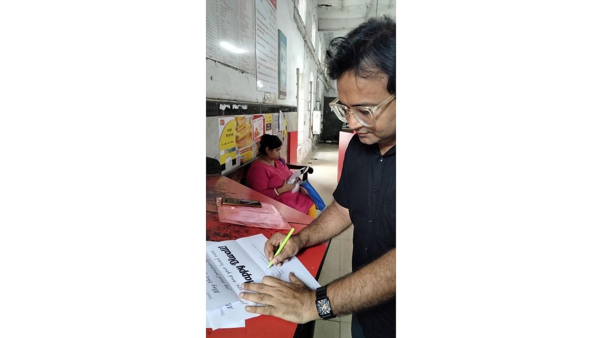 DH reporter signs Diwali greetings and hands them to a Kolkata post office. Credit: DH Photo