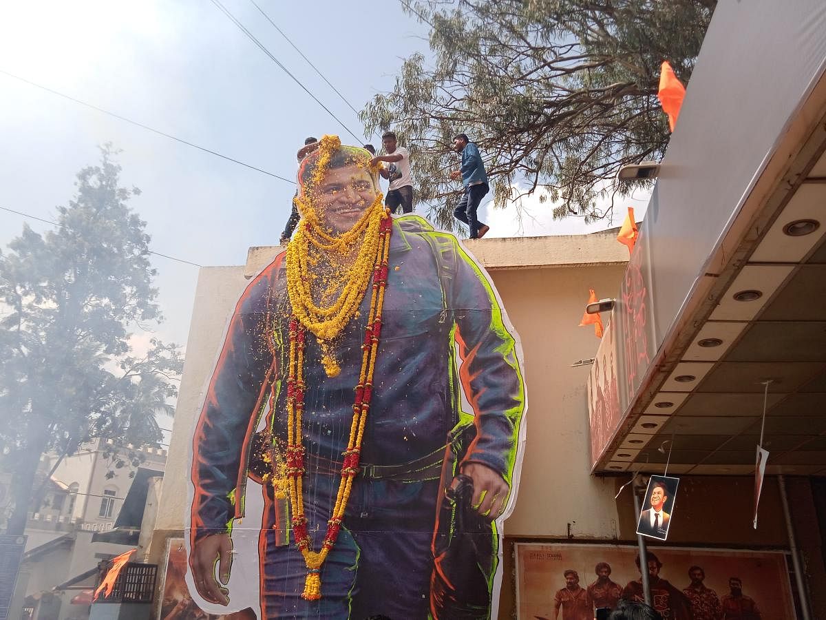 Fans garland and offers flowers to late actor Puneeth Rajkumar's cutout at Sudha-Apsara thatre premises in Hubballi.