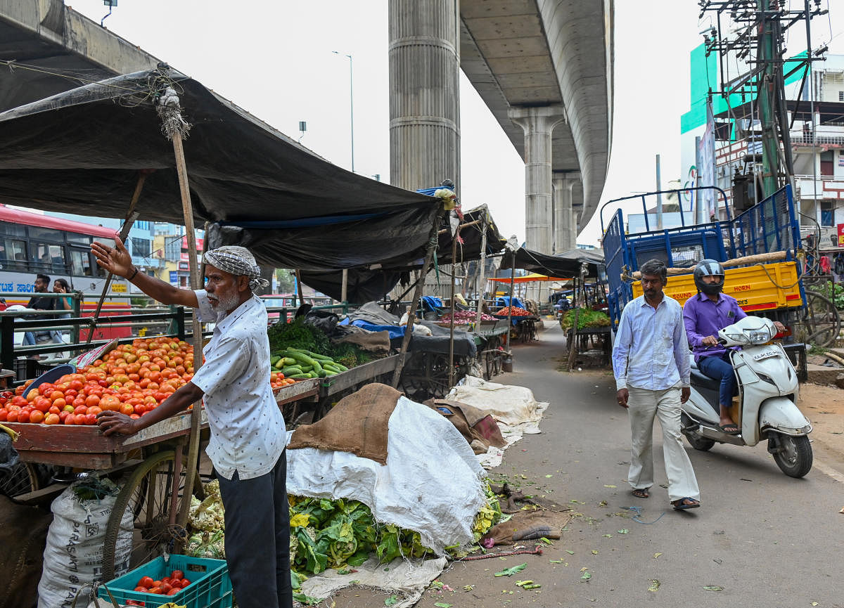 Street vendors and parked vehicles block a service road and a footpathin T Dasarahalli. DH Photo/B H Shivakumar