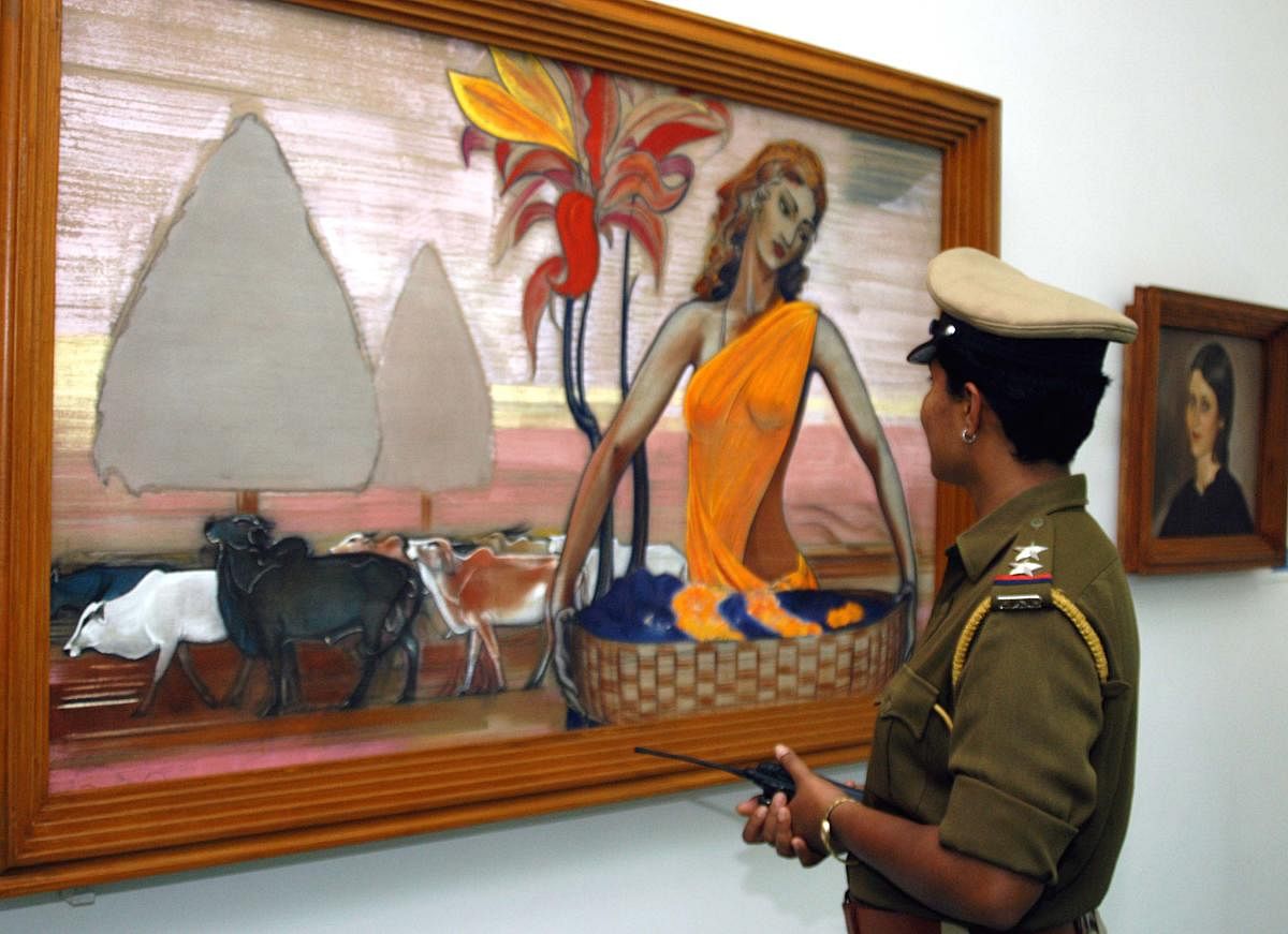 A lady police on Governor duty take time off to view an exhibition of paintings