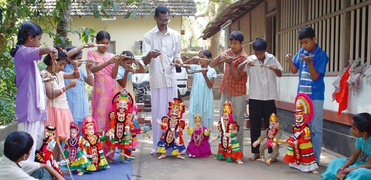 Artiste K V Ramesh teaches puppetry to children. 