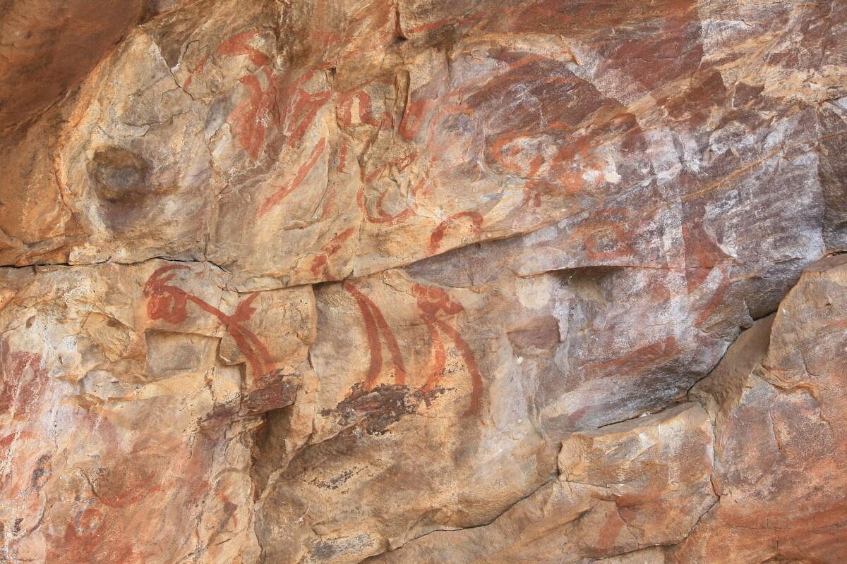 Painted inscriptions in 'Shankha Lipi' on the cliff behind the temple.