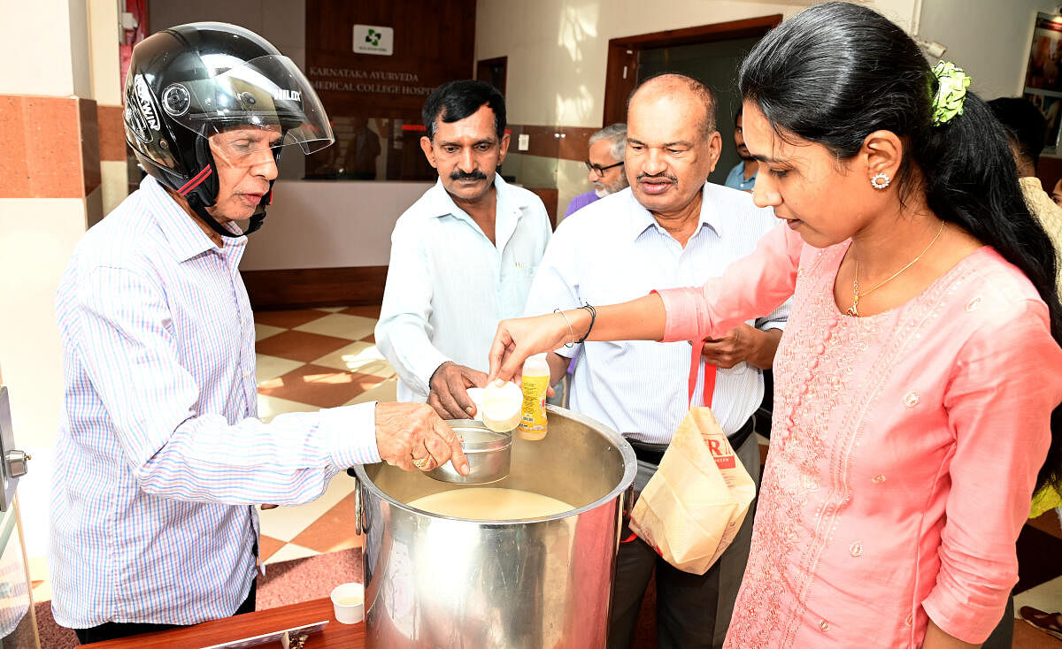 Students and faculty members of Karnataka Ayurvedic Medical University, Mangaluru distributing 'paaleda kashaya' to the public. DH photo/ Fakhruddin H