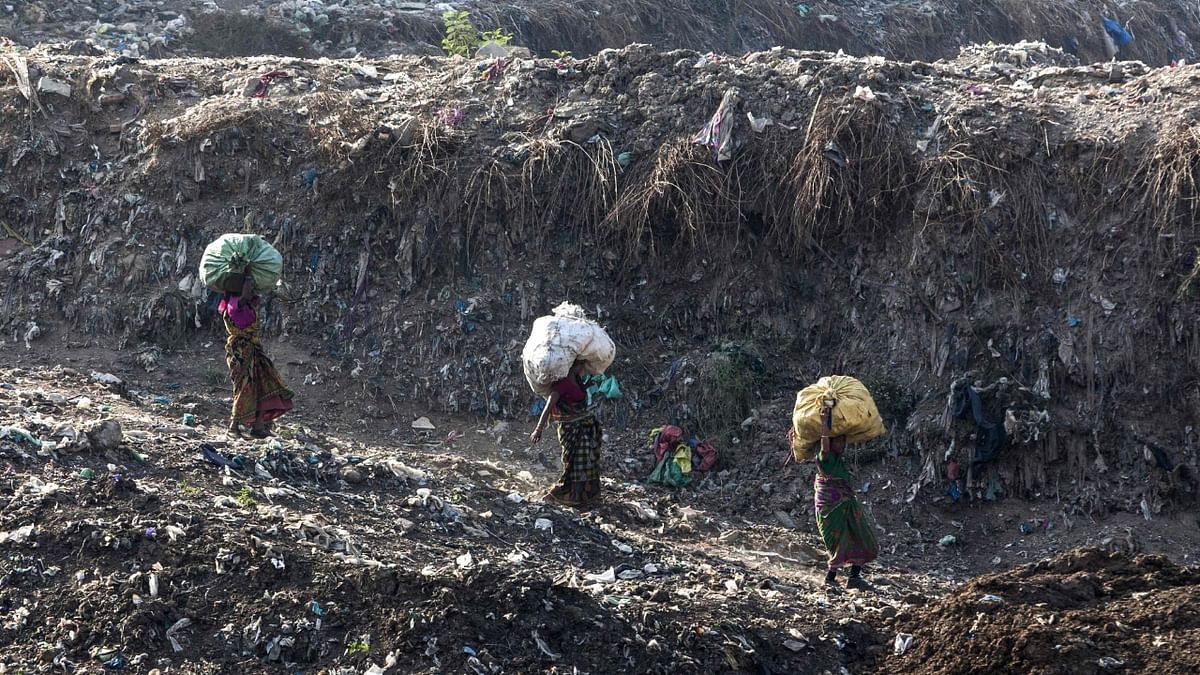 In this file photo taken on April 14, 2018, Indian rag pickers carry sacks of sorted recyclable materials at the Ghazipur landfill site in the east of New Delhi. Credit: AFP Photo