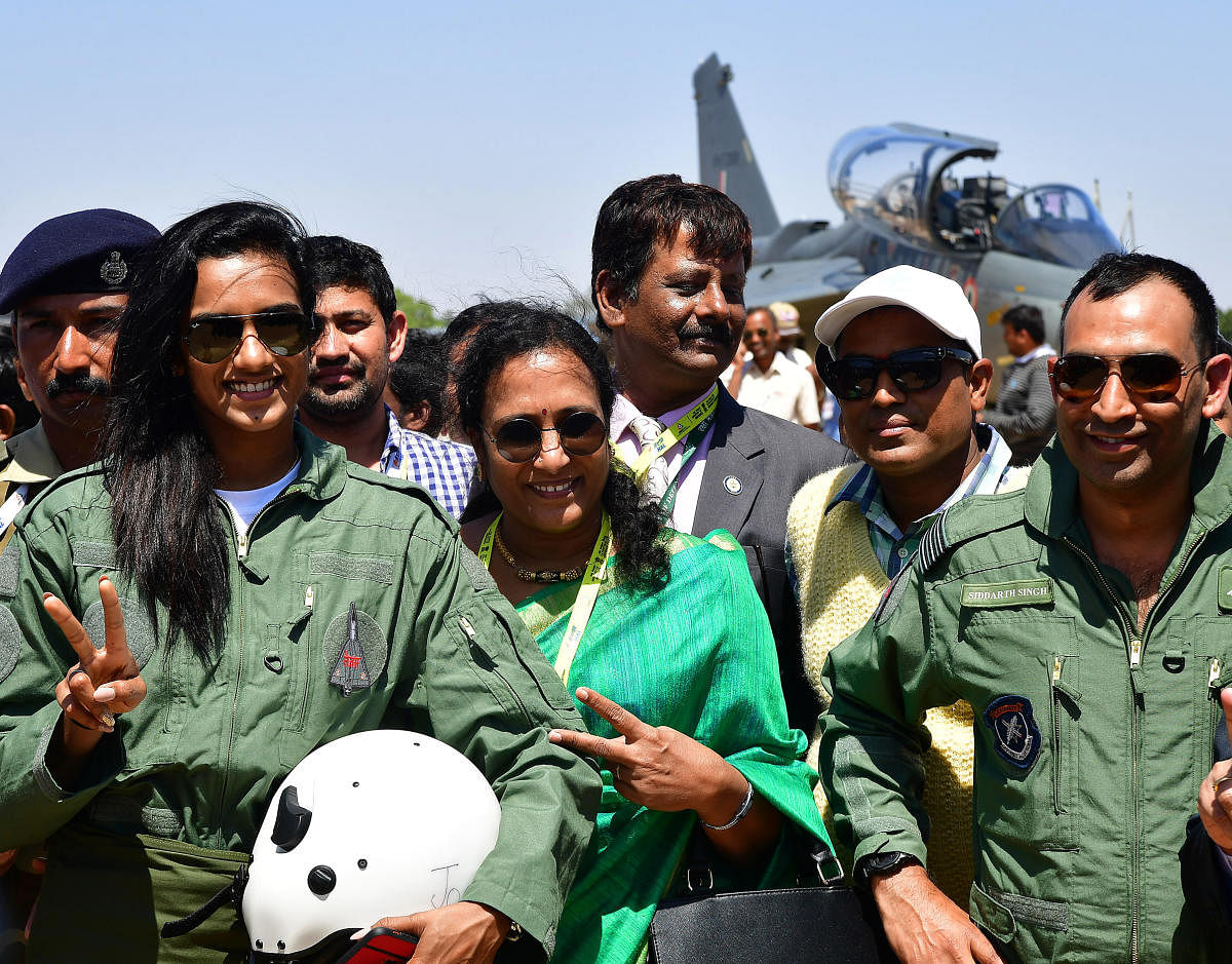 Waving to the crowds at the Yelahanka Air Force Station tarmac, Sindhu climbed onto the two-seater trainer version of the Tejas at 12.05 pm. Piloted by Wing Commander Sidharth Singh, the aircraft then went on a 35-minute sortie, climbing to an altitude of about 4 km to complete a series of loops and turns. DH Photo/ANAND BAKSHI