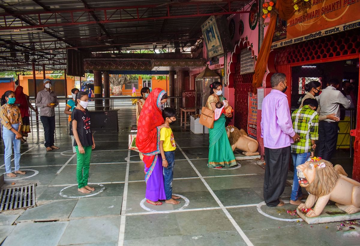 Devotees respecting social distancing norms arrive to offer prayers at Goddess Alopi Devi Shakti Peeth temple. Credit: PTI Photo