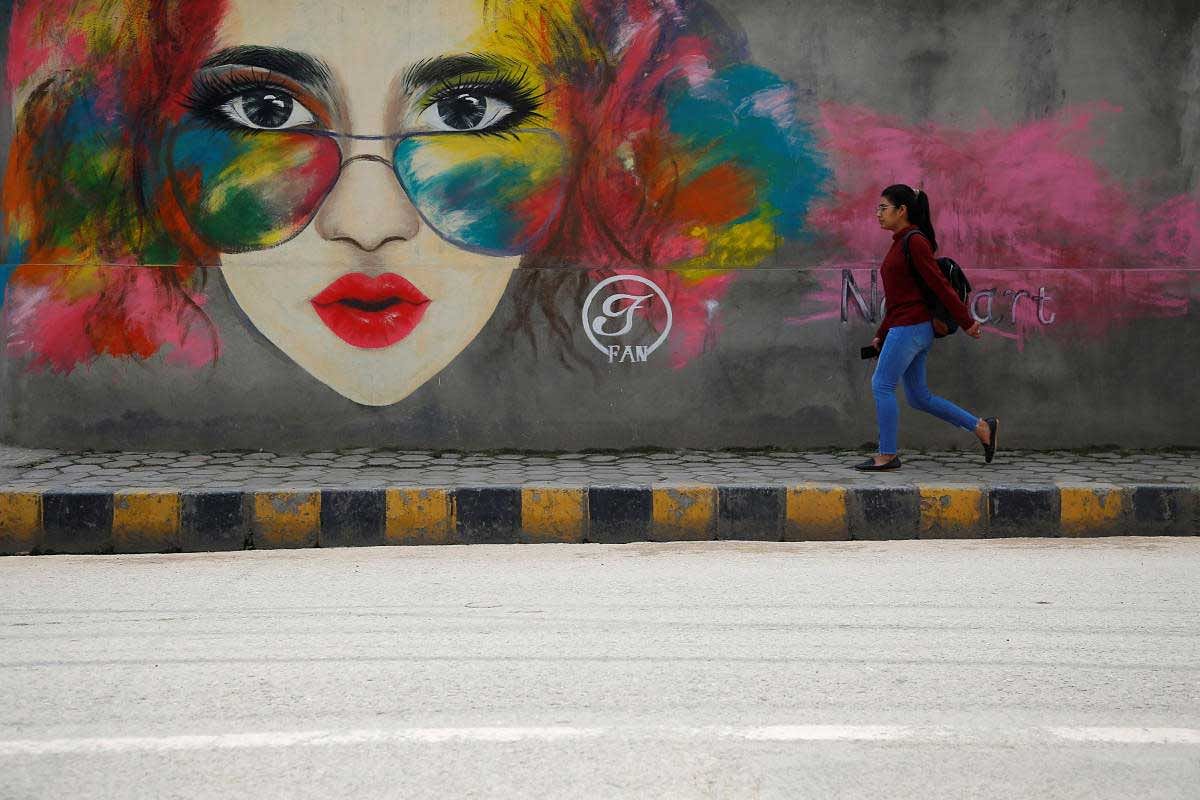 A girl walks past graffiti along the streets of Lalitpur, Nepal. Reuters Photo