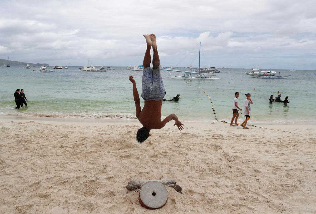 A performer somersaults as he practices for his nightly fire dance along a beach at Boracay. Reuters Photo
