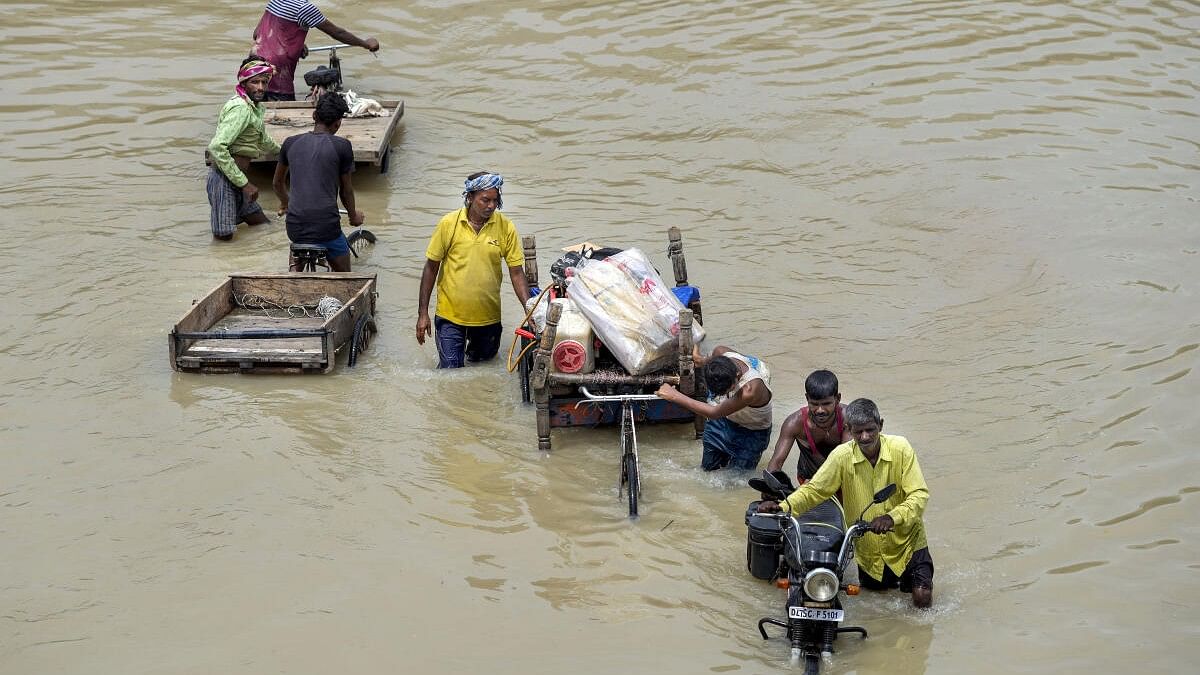 <div class="paragraphs"><p>People from low-lying areas carry their belongings while relocating to a safer place after the Yamuna river inundated the nearby areas following recent heavy monsoon rains, in New Delhi.</p></div>