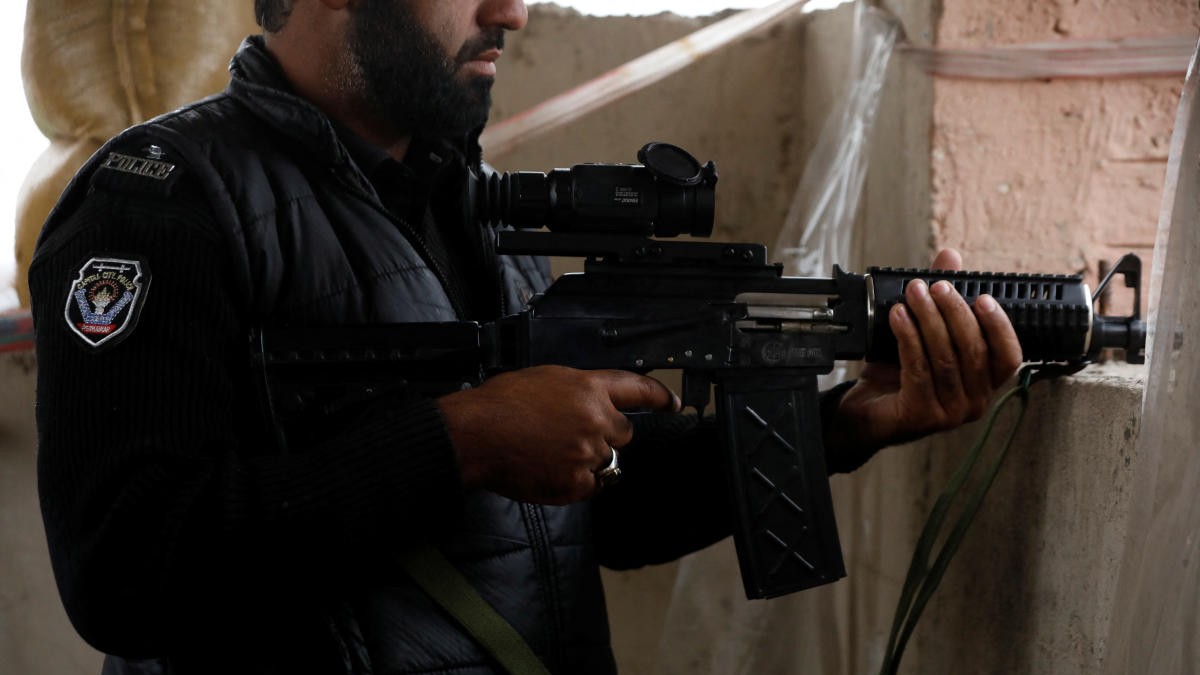 <div class="paragraphs"><p>A police officer holds a machine-gun with thermal binoculars attached to it, on the rooftop of Sangu's outpost, in the outskirts of Peshawar, Pakistan, February 9, 2023.</p></div>